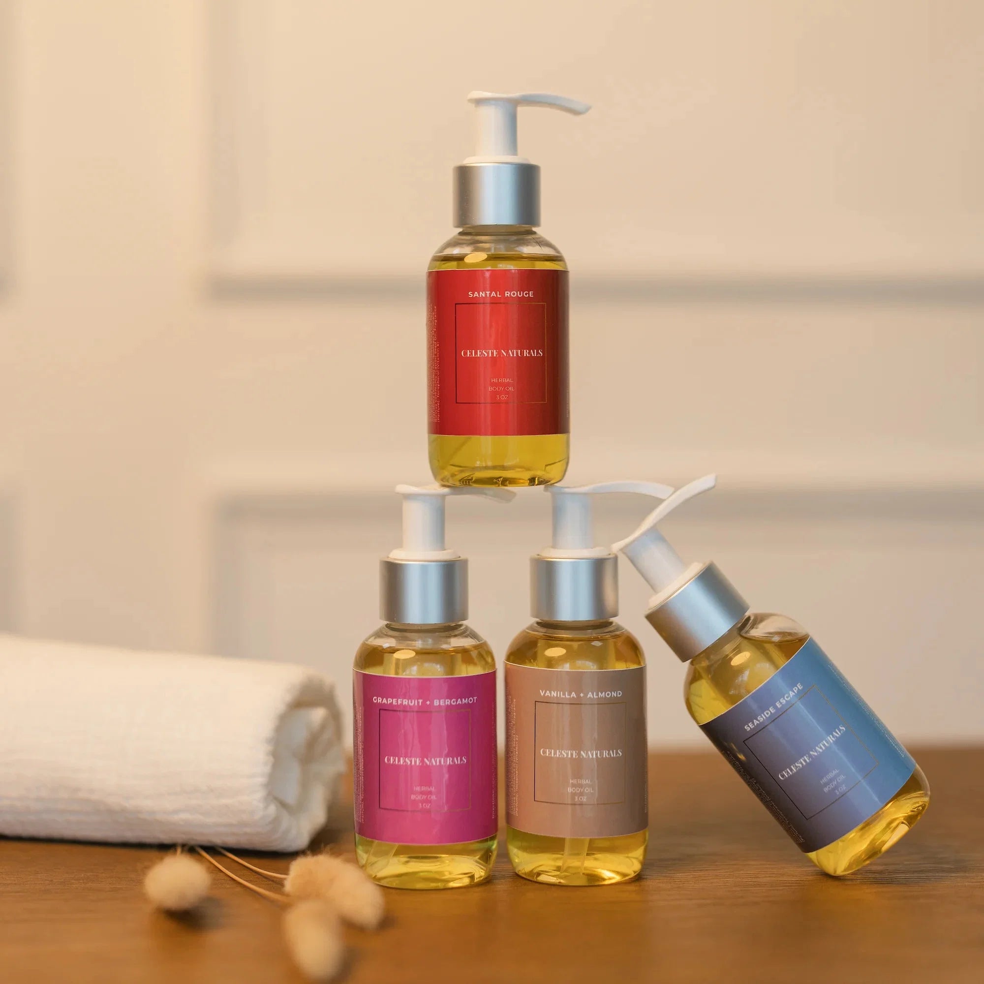 Four Celeste Naturals Herbal Body Oil bottles stacked, used in the What Is a Dry Oil blog post