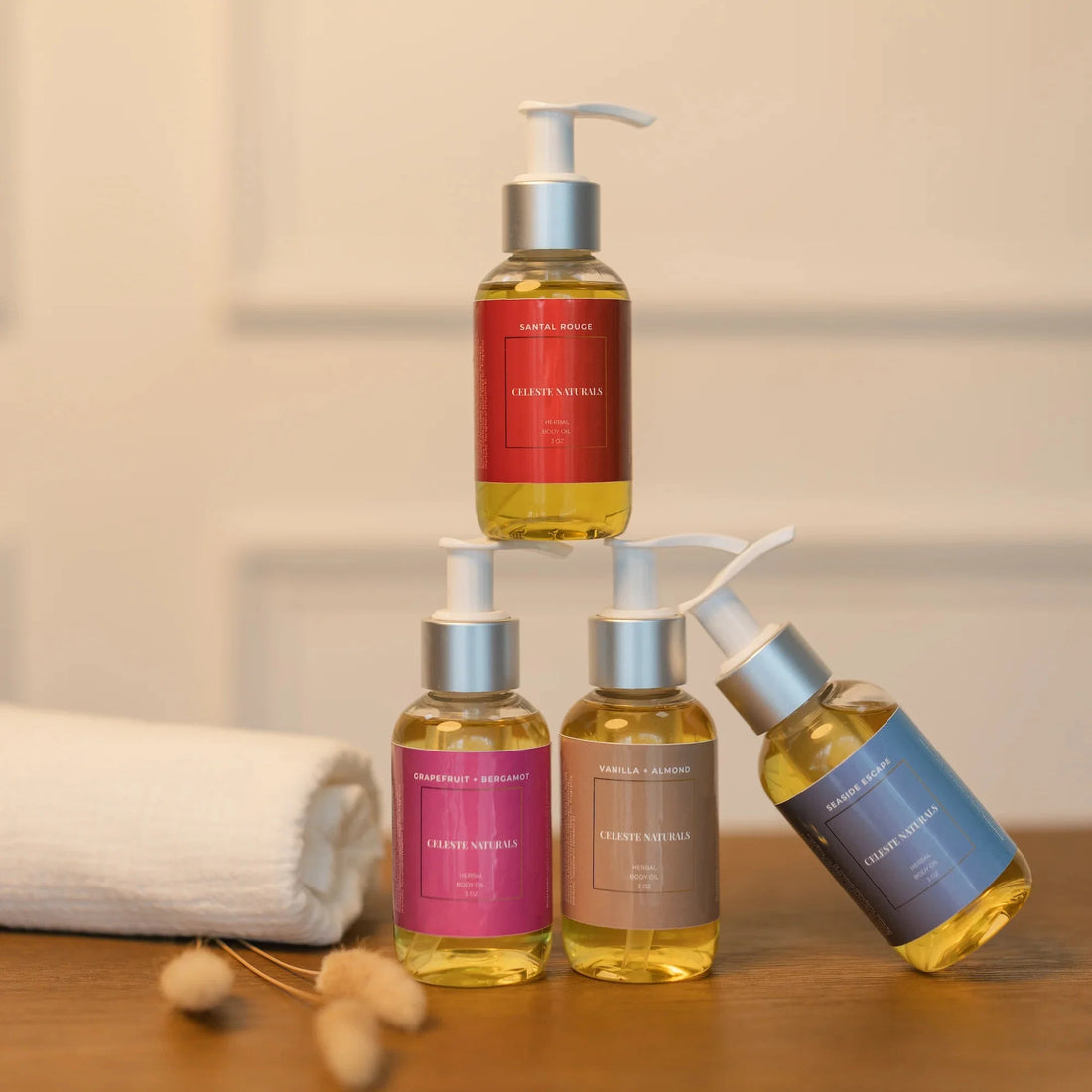 Four Celeste Naturals Herbal Body Oil bottles stacked, used in the What Is a Dry Oil blog post