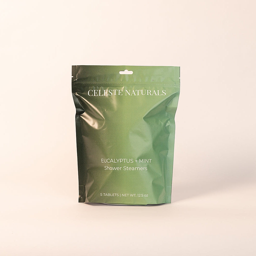 Green package of CELESTE NATURALS Eucalyptus Mint shower steamers on a beige background