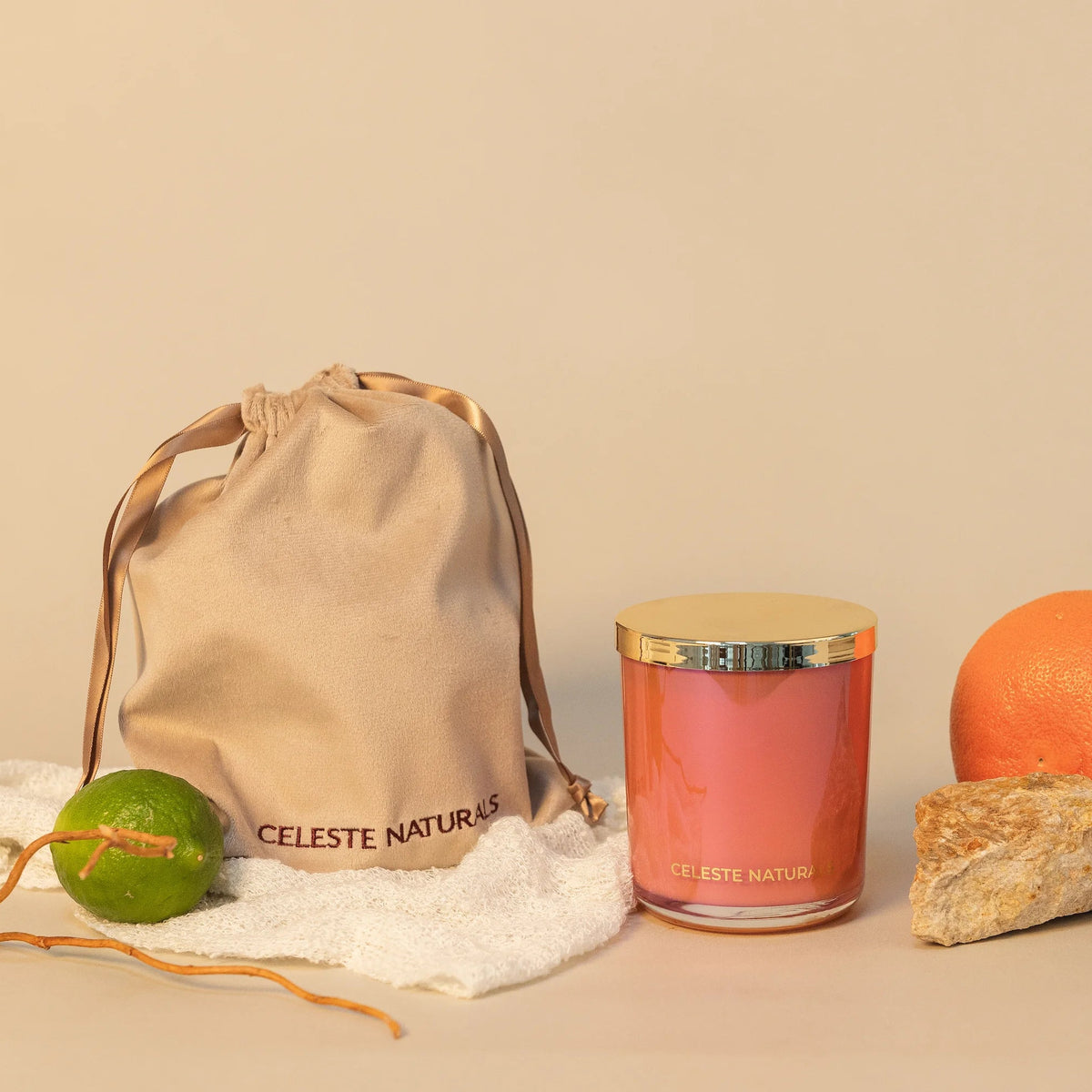 Celeste Naturals Grapefruit + Bergamot candle in a pink glass jar with a gold lid