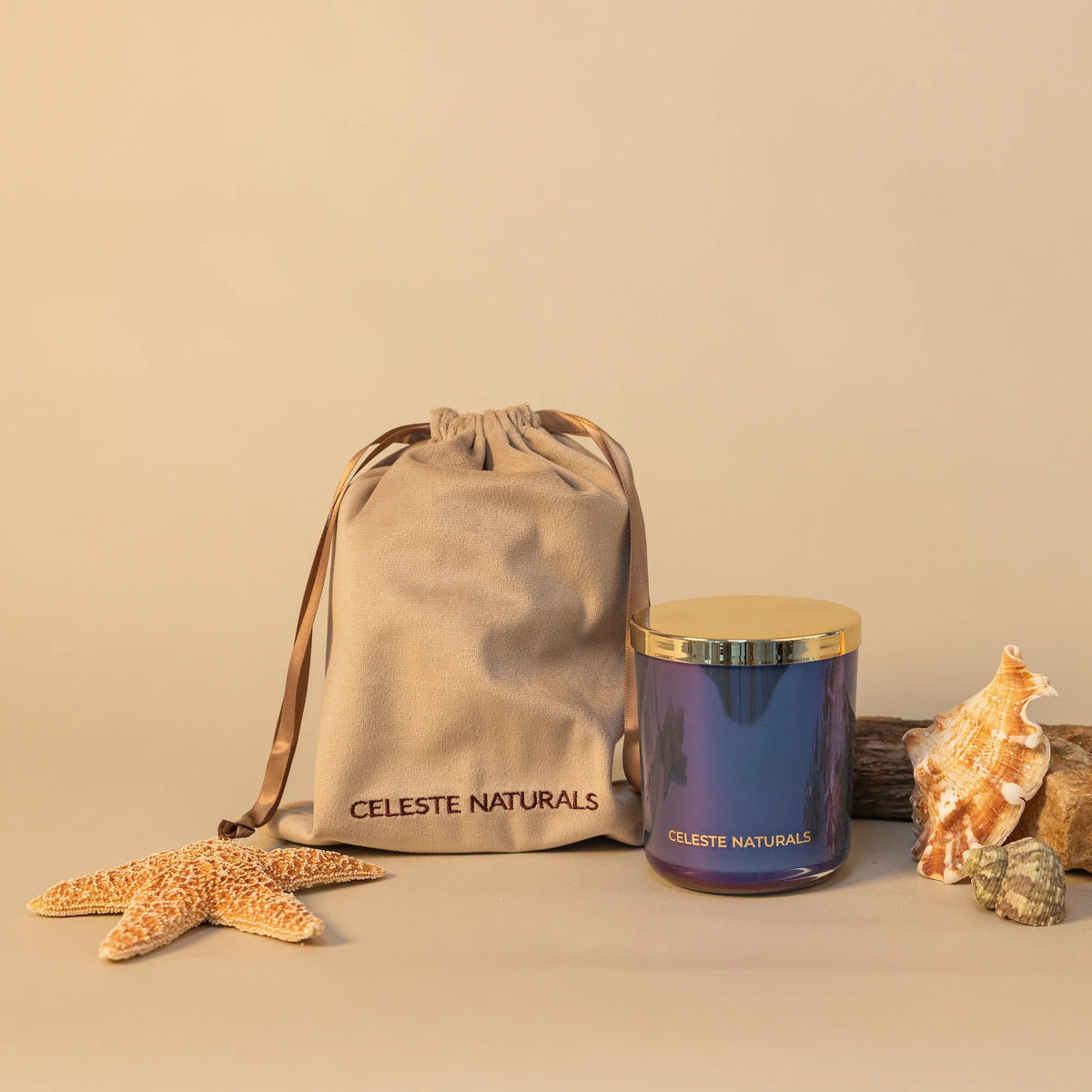 Celeste Naturals Seaside Escape candle in blue iridescent vessel with wood wick, gold top and beige drawstring bag